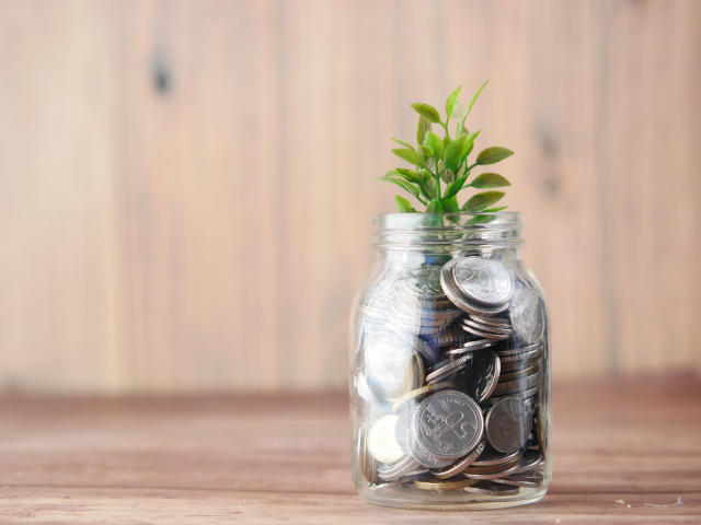 Coins in a jar saving for a staycation