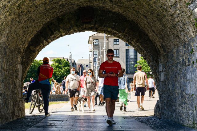 man walking through the spanish arch in galway city